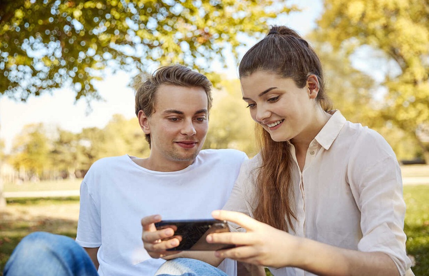 Young couple looking at smartphone in a park